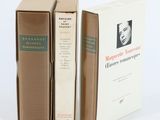 trois livres sont empilés sur une surface blanche