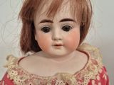 a close up of a doll wearing a red dress