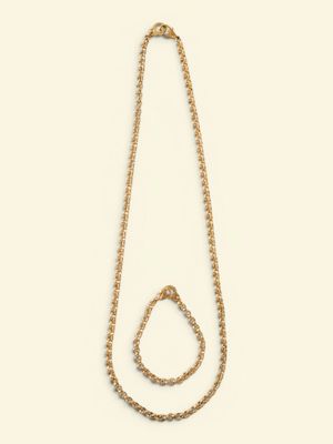 a gold chain necklace with a triangle shaped pendant on a white background