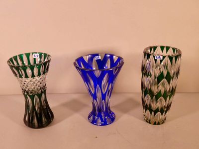 three different colored vases are lined up on a white surface