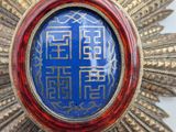 an image of a blue and gold medallion with chinese writing on it