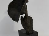 statue of a hand holding a hat on a black base