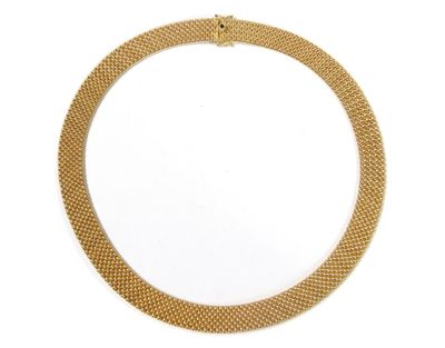 gros plan d'un collier en or sur fond blanc