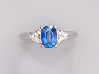 une bague à trois pierres, composée d'un saphir bleu et de diamants