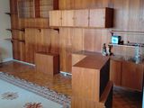 une pièce équipée d'un bureau, d'étagères et d'un tapis
