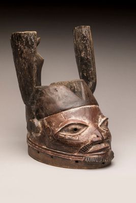 gros plan d'un masque en bois sur une surface blanche