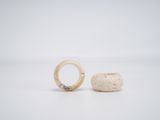 two rings are sitting on top of a rock on a white surface