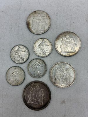 plusieurs pièces de monnaie sont disposées en cercle sur une surface blanche