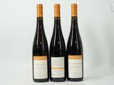 three bottles of wine sitting next to each other on a white surface