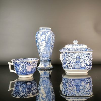 three blue and white vases and a bowl on a table