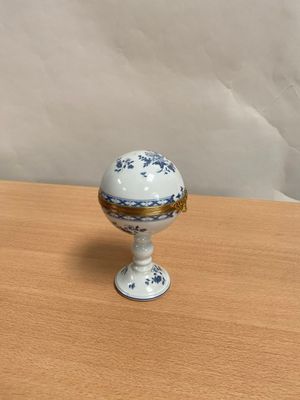 un petit œuf blanc et bleu posé sur une table en bois