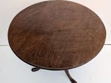 a small round table with a wooden top on a white floor