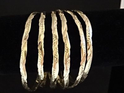 un gros plan d'un bracelet présenté sur un présentoir posé sur une surface noire