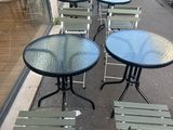many tables and chairs on the sidewalk outside of a building