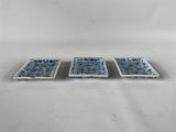 trois petits plats bleus et blancs posés sur une surface blanche