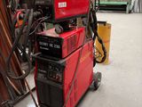 une machine rouge posée au sommet d'un tas de bois