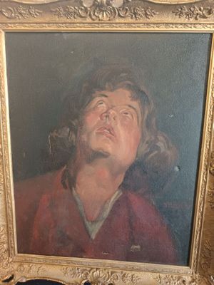 portrait of a man in a red shirt looking up in a gold frame