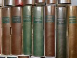 a lot of books that are stacked on a shelf