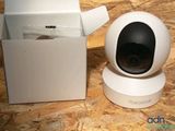 a white camera sitting next to a box on a table