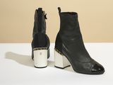 une paire de bottines en cuir noir à talon métallique