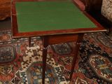 a small table with a green top sitting on a rug