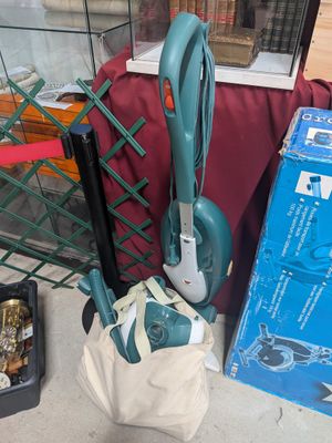 un aspirateur et un sac posés par terre à côté d'autres objets