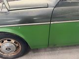 a green and black car parked on the side of the road