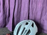 un rideau violet derrière un casque de vélo posé par terre