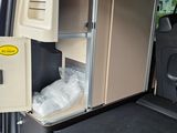 the back of a van with the door open and a storage compartment in the back