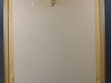 painting of a bird on a branch in a wooden frame on a wall