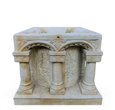 a white marble pedestal with columns and a cross on it