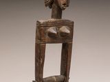 une statue en bois d'une femme avec un chapeau sur la tête