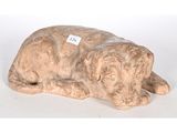 une statue représentant un chien couché par terre