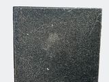 an old book with a black cover sitting on top of a table