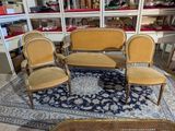 three chairs and a table in a room with a blue rug