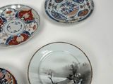 several plates with different designs are on a white surface