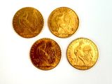 four different types of gold coins sitting on a white surface