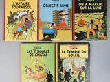 quatre livres pour enfants sont alignés sur une surface grise