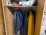 une armoire en bois sur laquelle sont posés des vêtements et d'autres objets