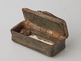 a small metal box with a ring inside of it