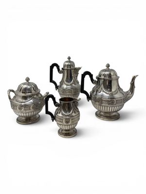 three pieces of silver tea and coffee set on a white surface