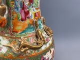 un vase avec un tableau posé sur une table