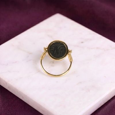 Gros plan sur une bague en or ornée d'une pierre noire