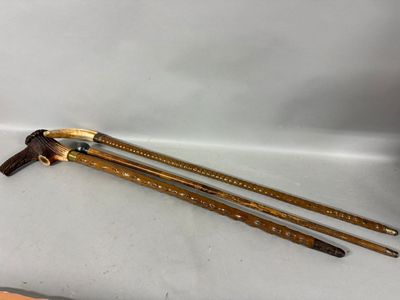 two wooden canes sitting on top of a table next to a knife