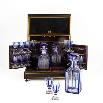 des bouteilles et des verres posés sur une table, avec une caisse en arrière-plan
