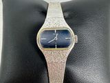 a close up of a wrist watch on a pillow on a pillow