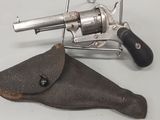 un pistolet et un étui posés sur une table blanche