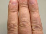 a woman ' s hand with a diamond ring on it