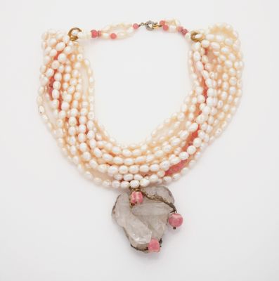 a close up of a necklace on a white surface