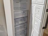 a white refrigerator with its door open on a pallet